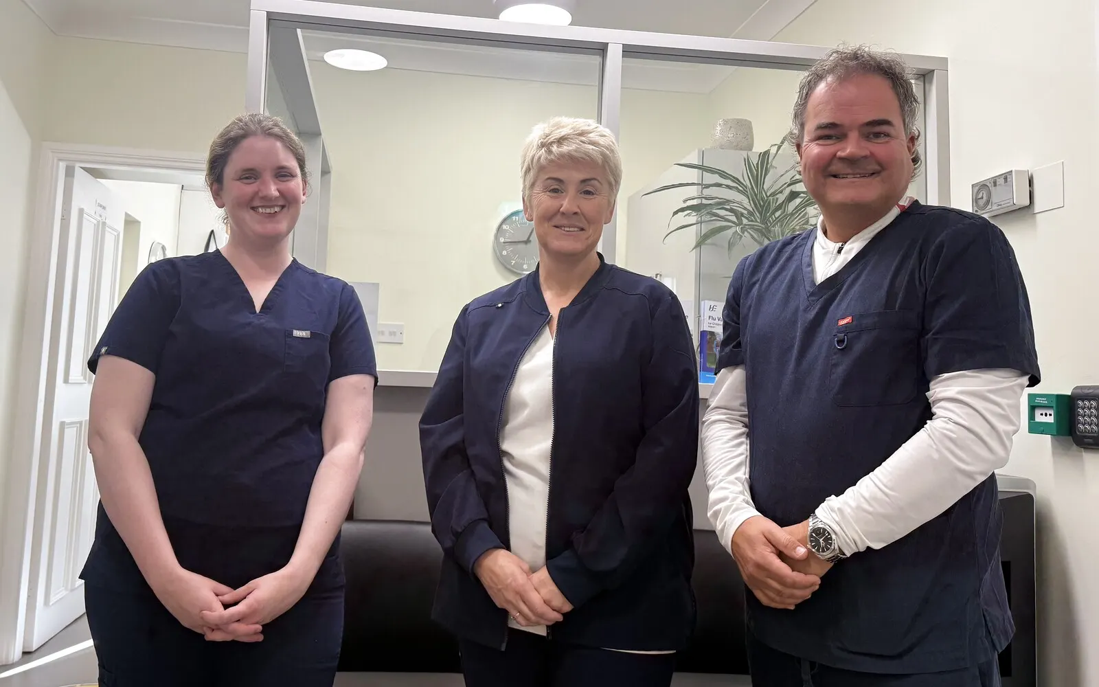 Three of the practice's clinicians, smiling, in the bright reception area of Renvyle Health Centre.